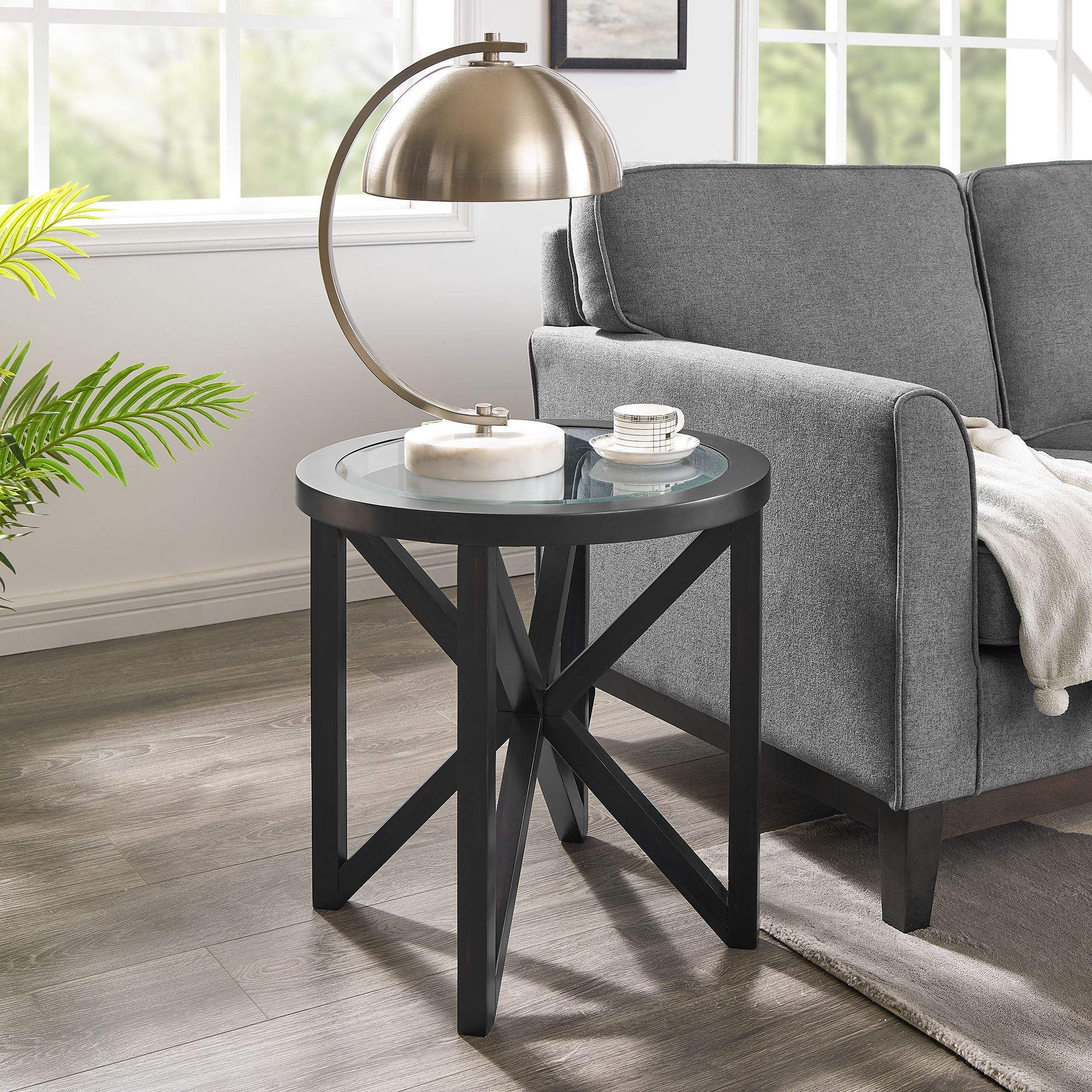 modern simple glass coffee table with round tempered glass top and black solid wood base in living room