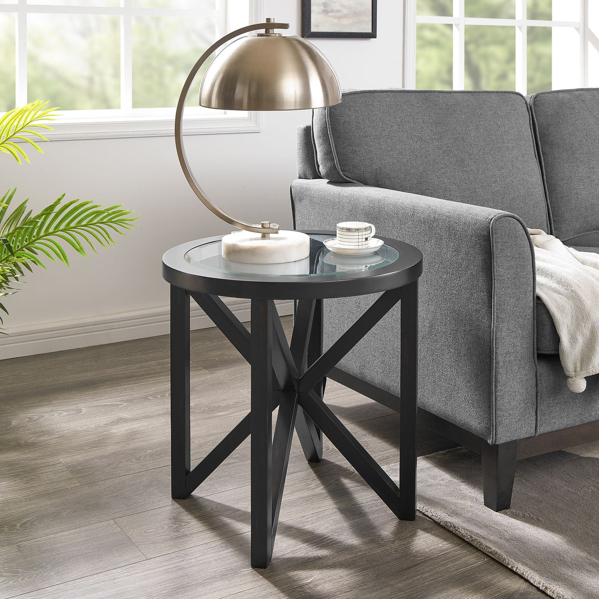 modern simple glass coffee table with round tempered glass top and black solid wood base in living room