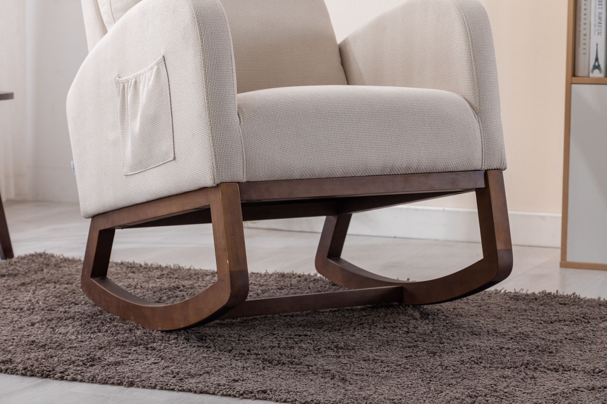 Beige COOLMORE rocking chair with solid wood legs and side pocket on a brown rug in a modern room