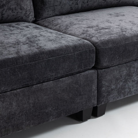 Close-up of ultra-soft XXXL dark grey chenille 3-seater sofa with plush cushions and black legs