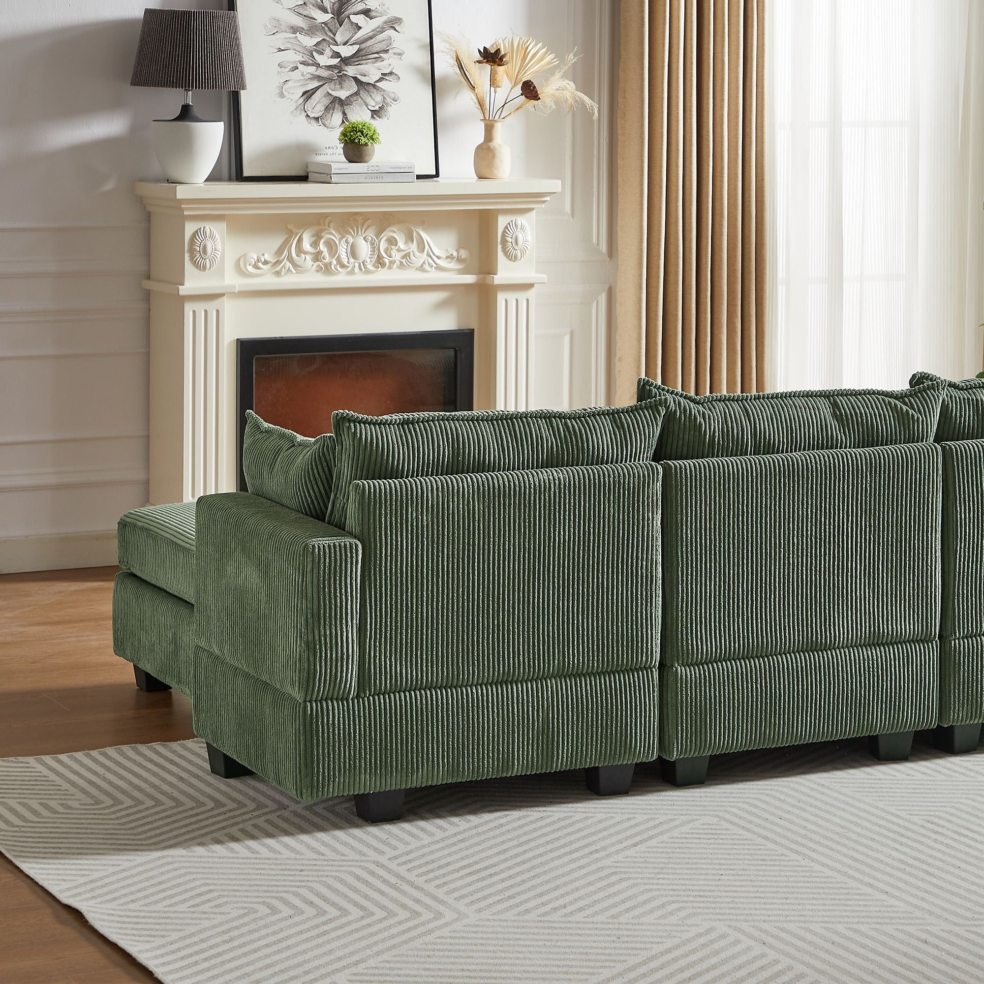 Green corduroy modular sectional sofa with storage ottoman and chaise in elegant living room.